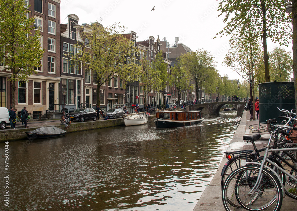 Canal  scene with a bicycles, boats and traditional Dutch houses in Red Light District. Amsterdam. Netherlands