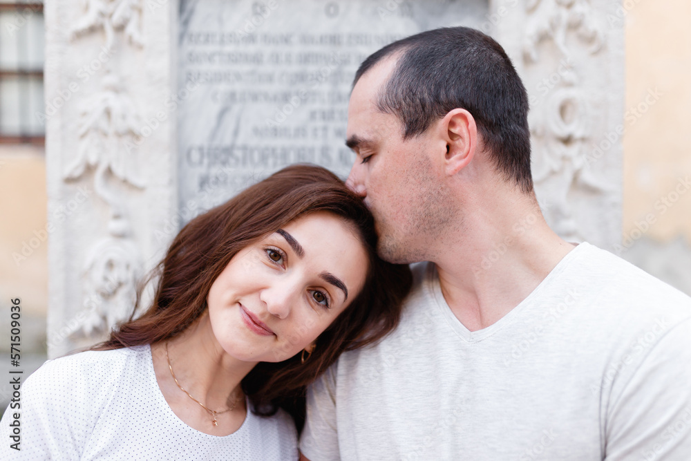 Man and woman romantically kissing on the city street in summer