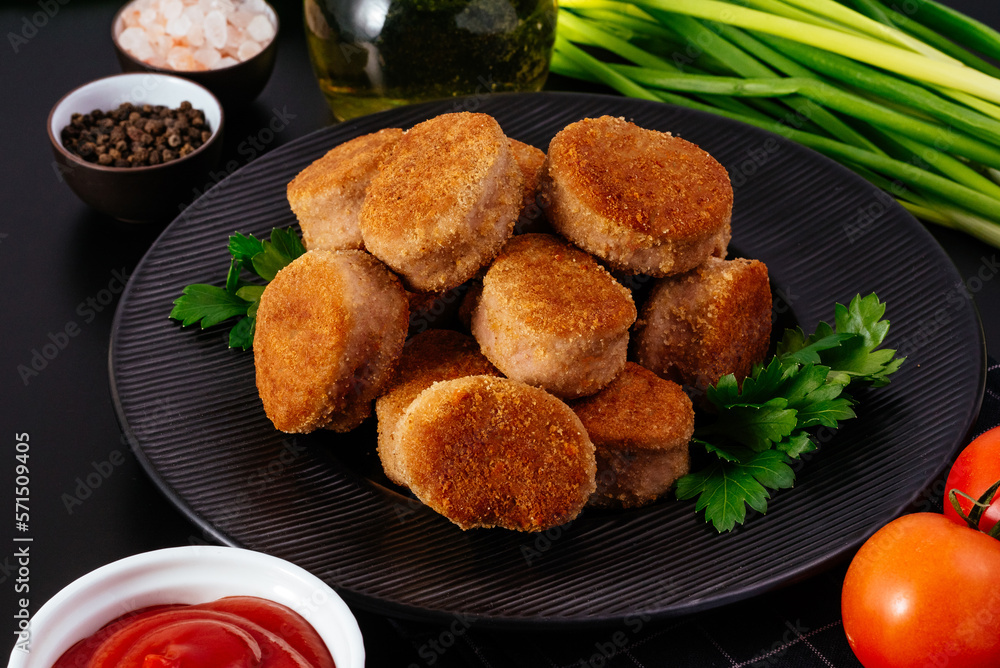 fried chicken nuggets on a black plate, ketchup in a saucepan, v fried chicken nuggets on a black plate, ketchup in a saucepan, v