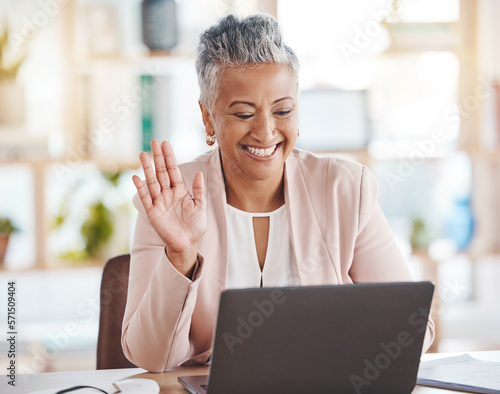 Video call, online and senior business woman waving greeting on internet, website or web conference from her office. Elderly, corporate and professional or executive employee using laptop for meeting