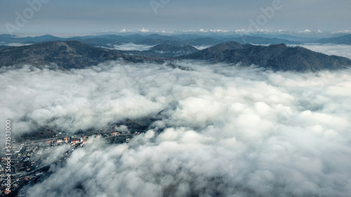 Above the clouds. Foggy layered mountain landscape with a city in Carpathians, Ukraine. photo