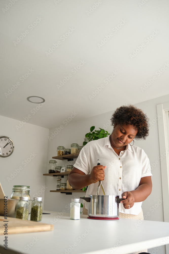Young cuban woman mashing potatoes to prepare cuban style stuffed potatoes. Young cuban woman mashing potatoes to prepare cuban style stuffed potatoes.