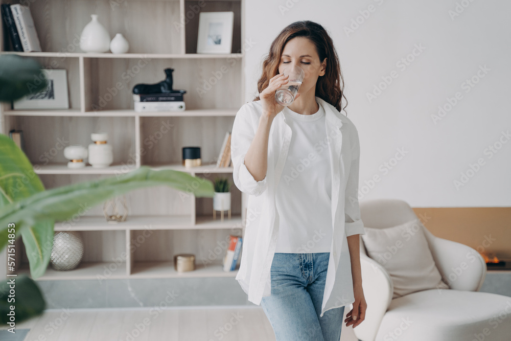 Attractive spanish woman is drinking clean water at home. Purified water for healthy lifestyle. Attractive spanish woman is drinking clean water at home. Purified water for healthy lifestyle.