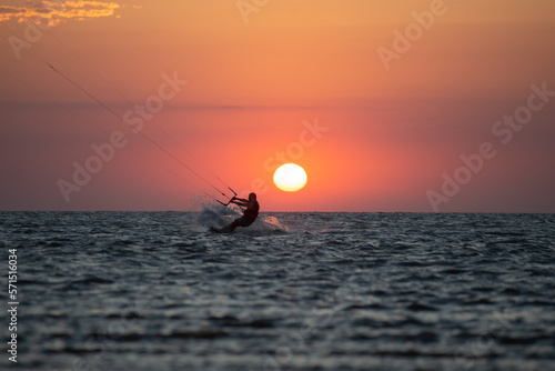 Hombre practicando kitesurf al atardecer en la ría de Punta Rasa.