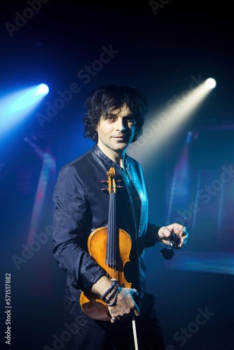 Violinist a player with a violin instrument in his hands. Artist of classical music or alternative music direction. Concept of stage art © Fotoproff