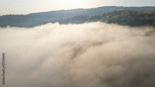 Fog covers the mountain forest. Mountain inversion. Highlands under the fog. Foggy sunrise in the mountains. Aerial view of fog-covered forest.
