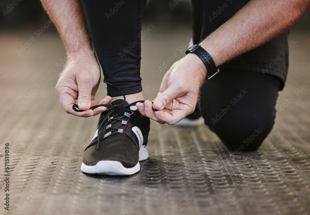 Fitness, hands and tie shoes in gym to start workout, training or exercise for wellness. Sports, athlete and man tying sneakers or footwear laces to get ready for exercising or running for health.
