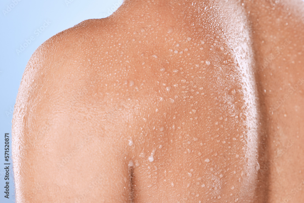 Fototapeta premium Water drop, skincare and back of man in studio for cleaning, body care or cosmetic on blue background. Shower, skin and guy wellness model relax in luxury, moisture and gentle, cleansing or treatment