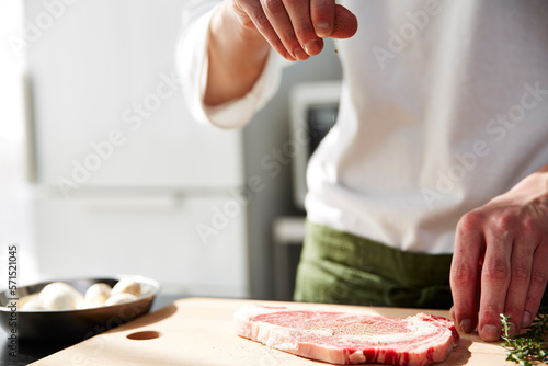 生肉に下味をつける男性の手元 photo
