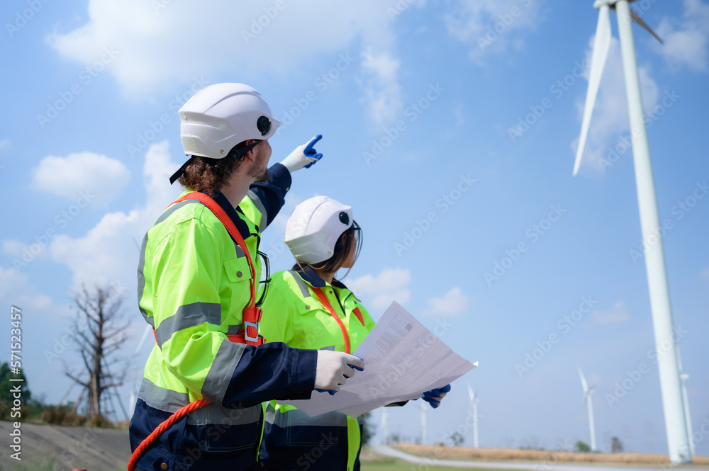 Windmill Task Man and female engineer stationed at the Natural Energy Wind Turbine ...
