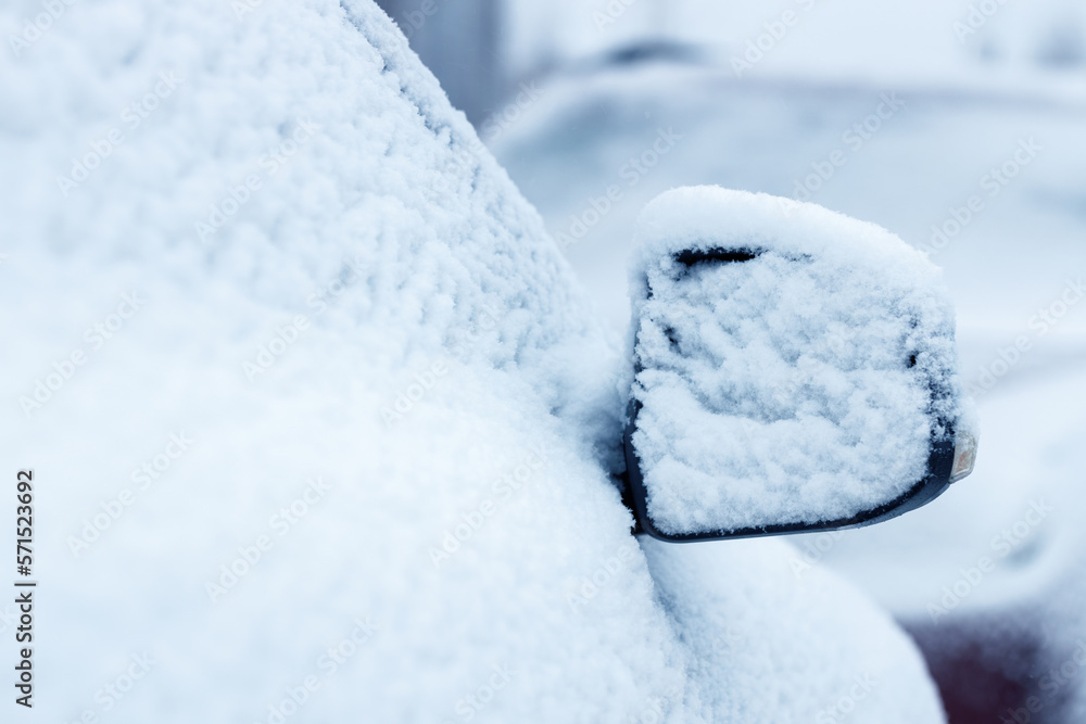 The side mirror of a car covered in snow. Selective focus copy space