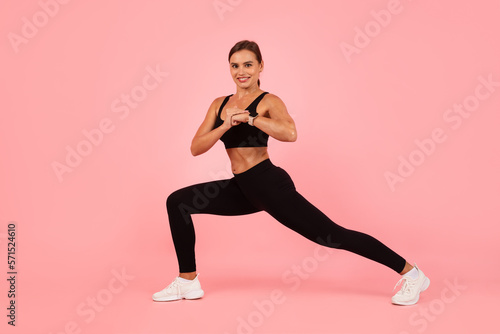 Portrait Of Young Athletic Woman Training Over Pink Background In Studio
