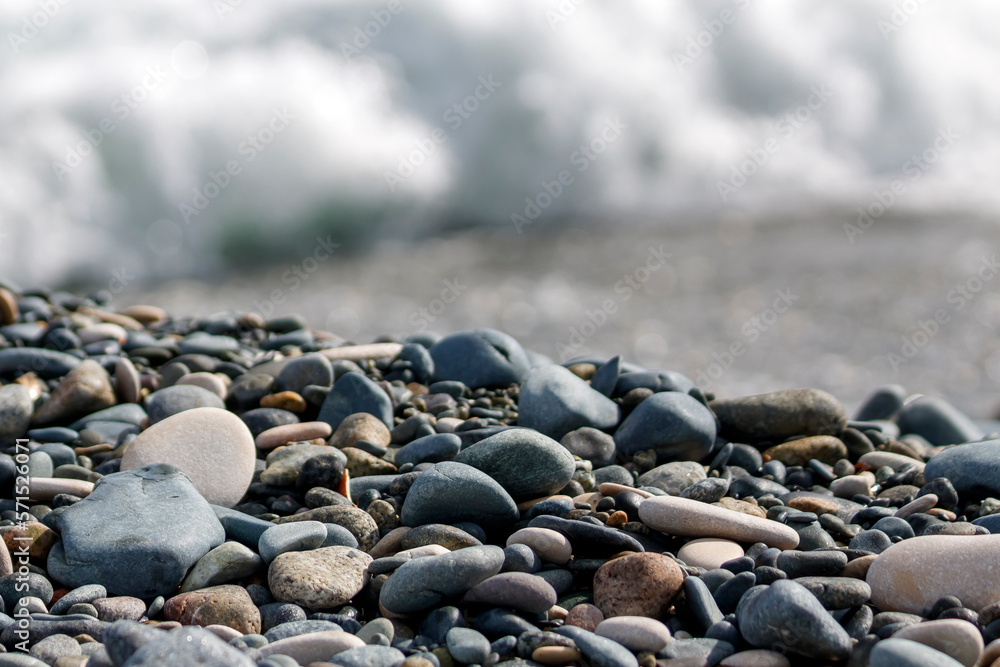 Beach stones and pebbles in front of blurry sea wave Beach stones and pebbles in front of blurry sea wave