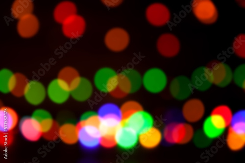 Round, bright, blurry garland lights. Abstract illustration of colorful bokeh lights on a dark background.