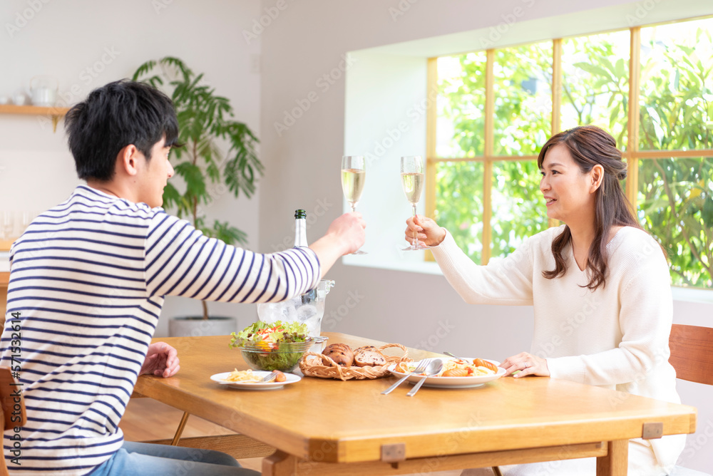 休日にシャンパンで乾杯する30代夫婦 休日にシャンパンで乾杯する30代夫婦