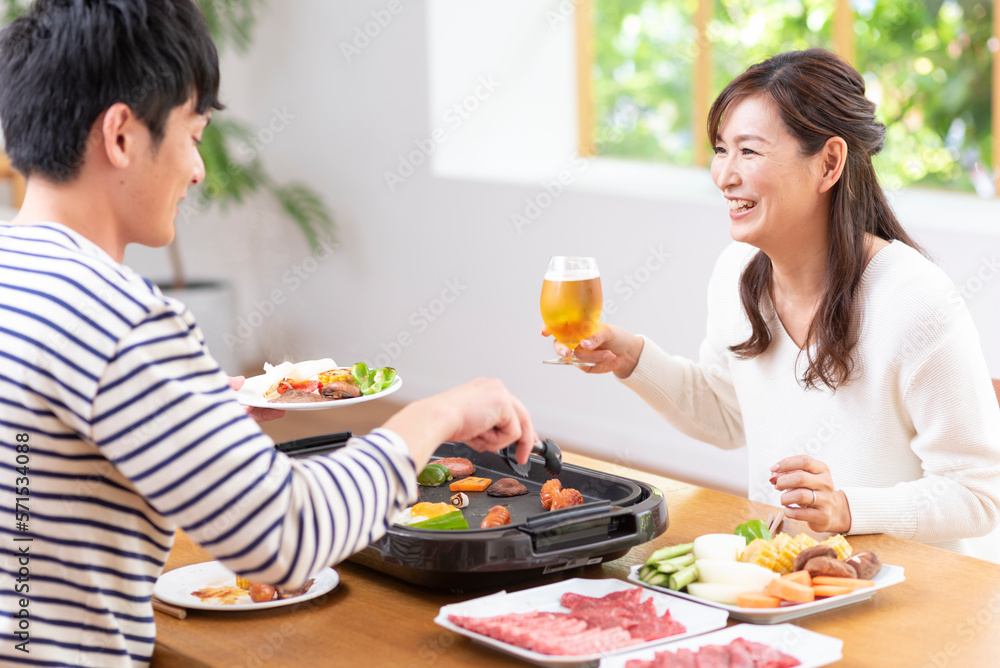 生ビールで焼肉を食べる30代夫婦 生ビールで焼肉を食べる30代夫婦