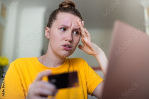 Internet fraud. Nervous sad upset unhappy confused young woman, stressed worried lady having problem with paying, buying online, shopping, stolen money, payments with credit blocked bank card