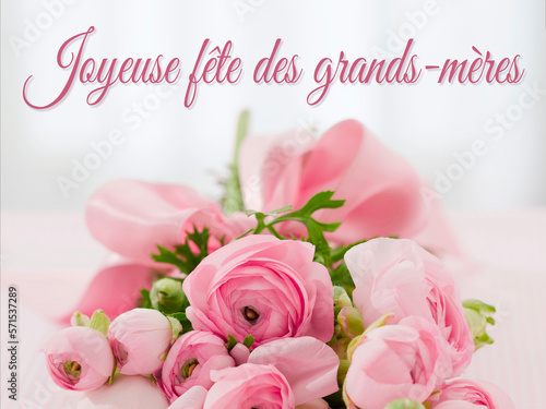 carte ou bandeau pour souhaiter une joyeuse fête des grands-mères en rose sur un fond gris en effet bokeh et en dessous  un bouquet de fleurs rose  photo