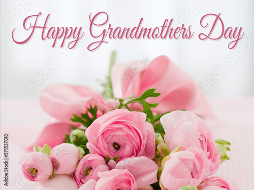 card or banner to wish a happy grandmother's day in pink on a gray background in bokeh effect and below a bouquet of pink flowers