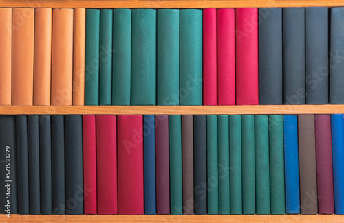 bookcase with books with different colored spines