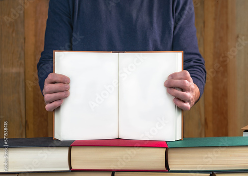 man holding a book showing its blank pages