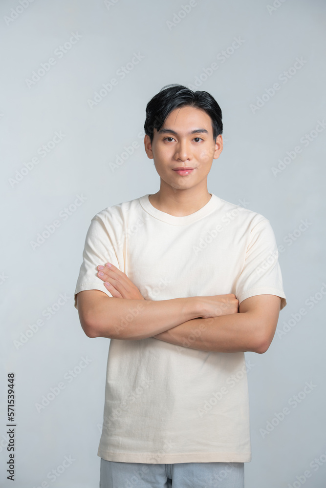 Casual young man looking at camera with arms crossed and satisfaction