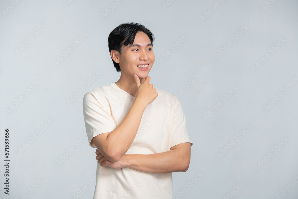 Handsome young Asian man smiling with hand on chin isolated Handsome young Asian man smiling with hand on chin isolated