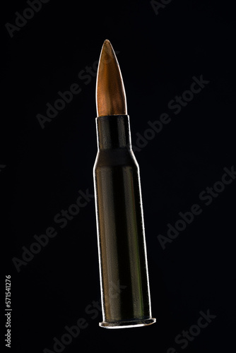 Rifle bullet long cartridge on black background. Army or hunting weapon shot object, violence and danger symbol.