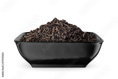 Black dry tea leaves in black bowl isolated on white. Side view.