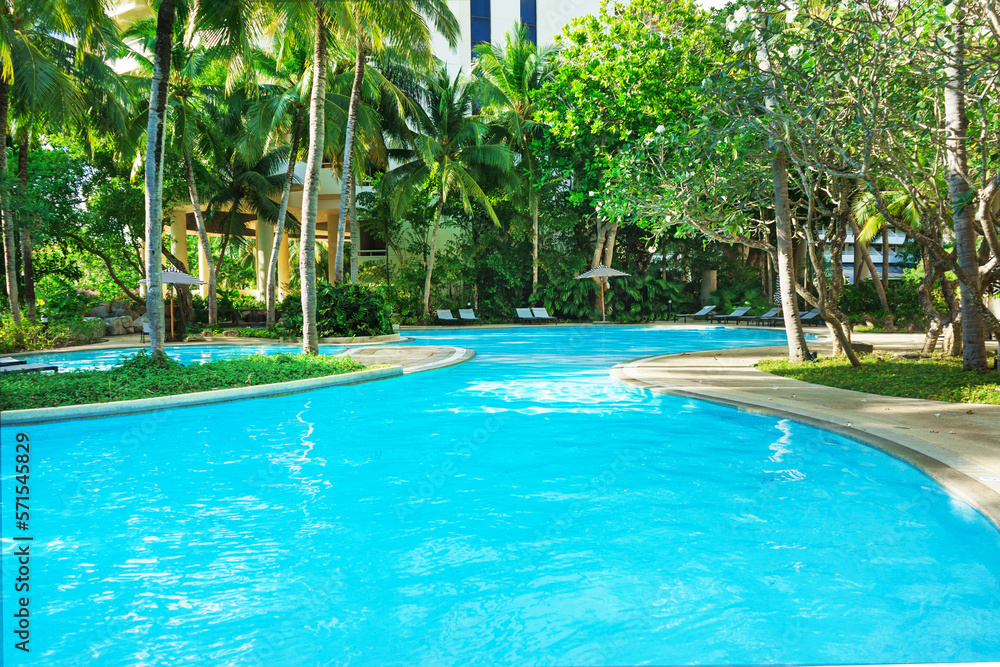 Beautiful luxury swimming pool with palm trees. Thai, Phuket. Vacation concept.