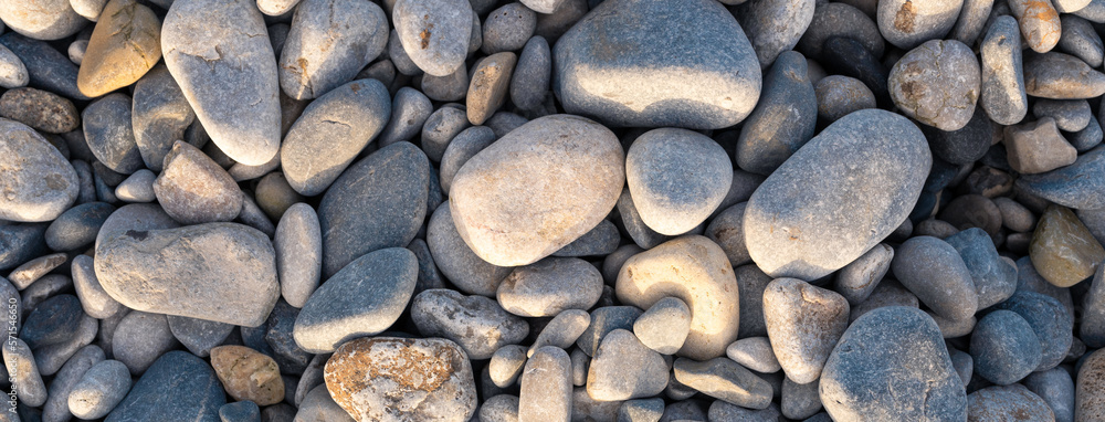 Pebbles on Penmon Beach, Textures. Varying sizes of pebbles lit with the morning sun. Grey, blues and yellows Pebbles on Penmon Beach, Textures. Varying sizes of pebbles lit with the morning sun. Grey, blues and yellows