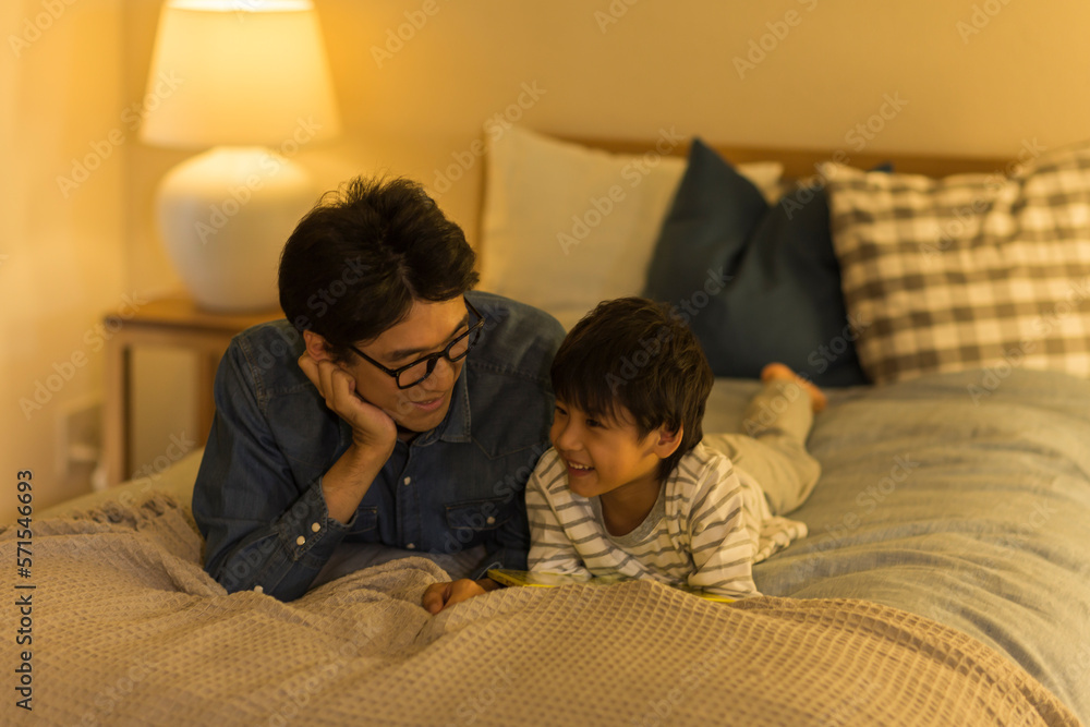 ベッドで会話をする父親と息子 ベッドで会話をする父親と息子