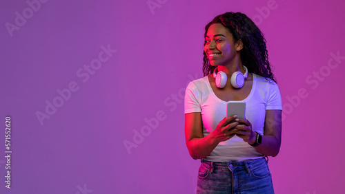 Smiling Black Female Holding Smartphone And Looking Aside At Copy Space