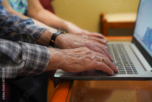 unrecognizable older couple typing on the computer. technology in old age
