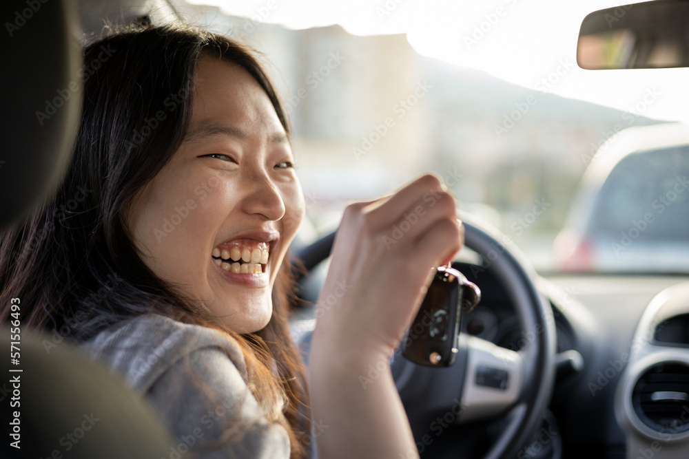 Asian woman looking at the back seats of her car and smiling happily showing the car key with positive expression during the trip, people enjoy laughing the transportation,happy woman on the trip. Asian woman looking at the back seats of her car and smiling happily showing the car key with positive expression during the trip, people enjoy laughing the transportation,happy woman on the trip.
