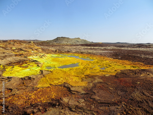 Surreal red and yellow mineral formation with blue pond at Danakil Depression with strong colours in Ethiopia  Africa