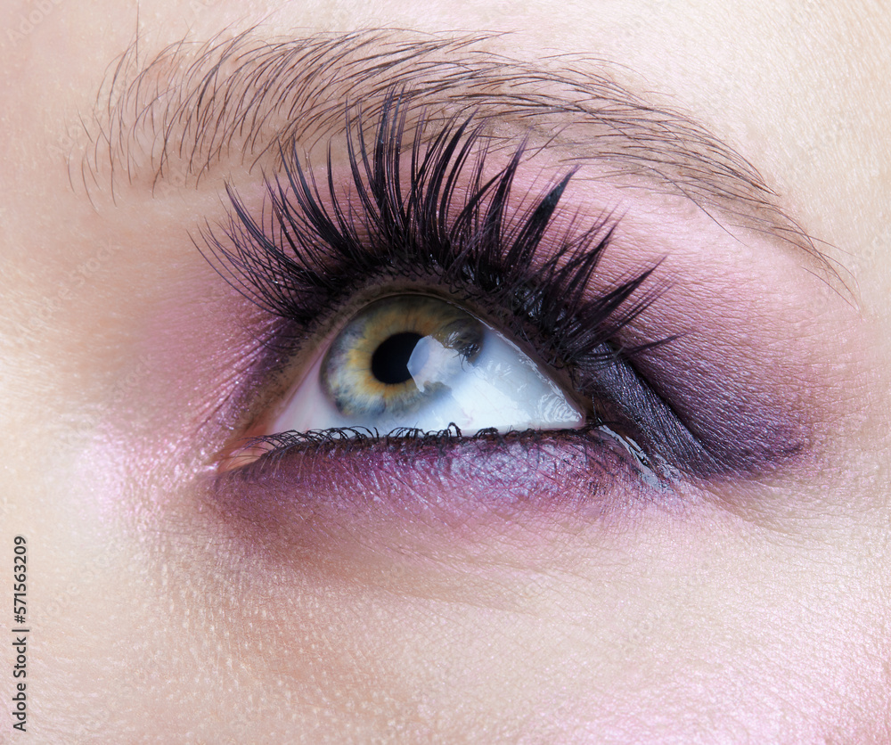 Obraz premium Closeup macro shot of human female eye. Woman with lilac beauty eyes makeup.