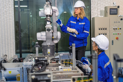Female robotic factory workers use tablet pc quality checking Circuit Boards after assembly © Tongpool