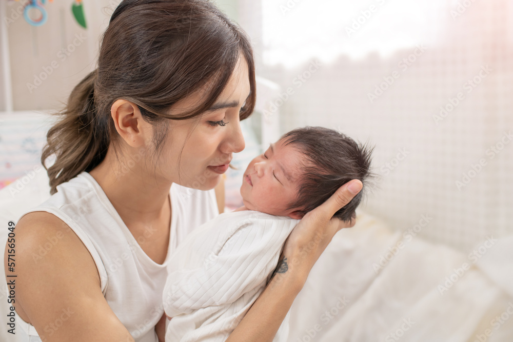 happy loving family. mother playing with her baby hugging in the bedroom , portrait of asian mother playing with newborn baby, health care family love together. asian girl lifestyle.. happy loving family. mother playing with her baby hugging in the bedroom , portrait of asian mother playing with newborn baby, health care family love together. asian girl lifestyle..