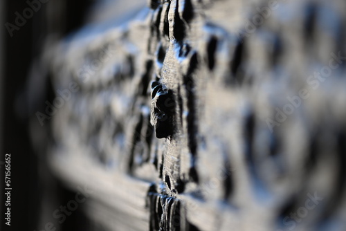 Diagonal, blurred view of an old wood carving on the entrance door of a church.