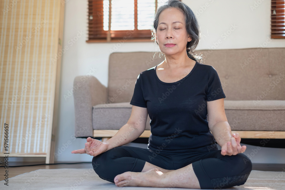 Asian elderly woman meditating practicing yoga for good health At an older age, it's about taking care of your body's health at home on a relaxing day. good health concept Asian elderly woman meditating practicing yoga for good health At an older age, it's about taking care of your body's health at home on a relaxing day. good health concept