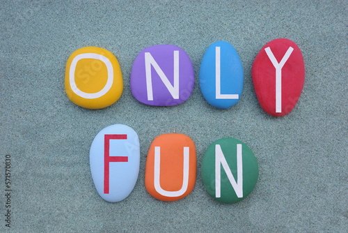 Only Fun, creative slogan composed with multi colored stone letters over green sand