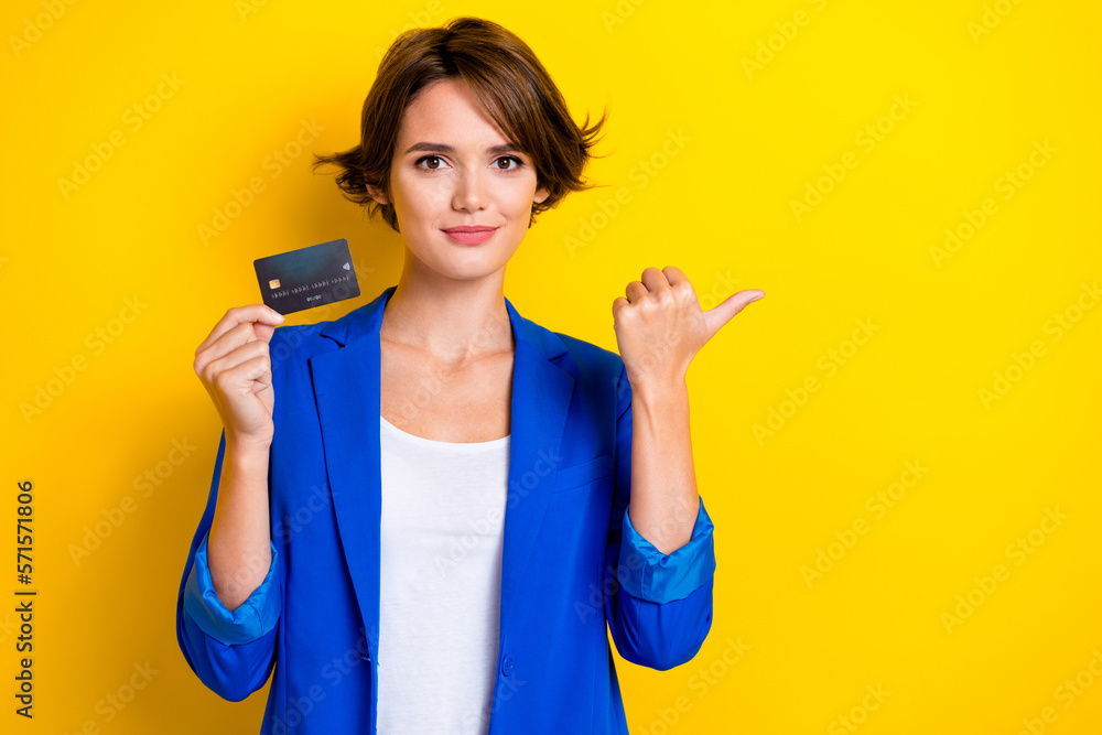 Photo of young promoter beautiful lady wear trendy outfit hold debit card save money direct thumb mockup banking isolated on yellow color background - obrazy, fototapety, plakaty 