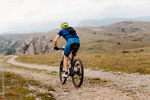 man cyclist biking on mountain path on mountain bike