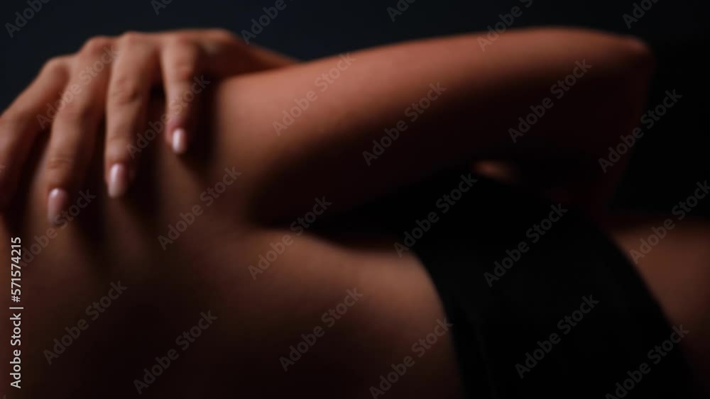 portrait of a sexy beautiful young woman in a swimsuit with wet hair on a black background. vertical portrait of a sexy beautiful young woman in a swimsuit with wet hair on a black background. vertical