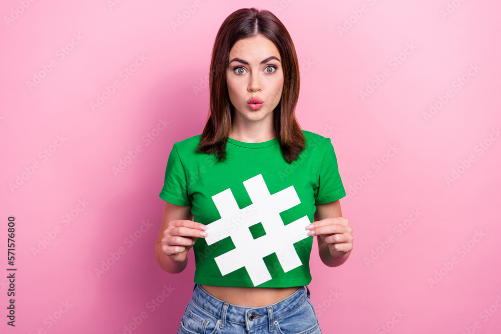 Photo of impressed nice person pouted lips arms hold paper hashtag symbol isolated on pink color background Photo of impressed nice person pouted lips arms hold paper hashtag symbol isolated on pink color background