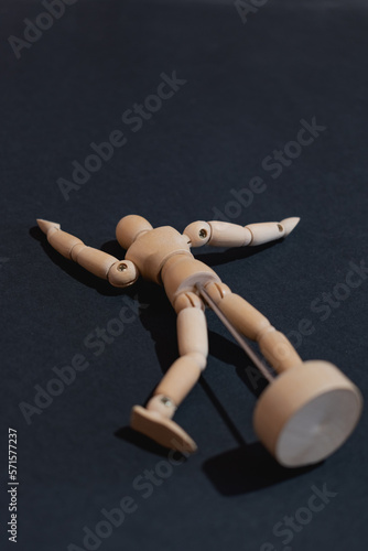 Wooden mannequin or model lying on its back on a black background. Appeals to flight, despondency, fatigue, sadness or other mental states of the human being.