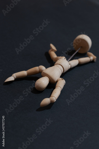 Wooden mannequin or model lying on its back on a black background. Appeals to flight, despondency, fatigue, sadness or other mental states of the human being.
