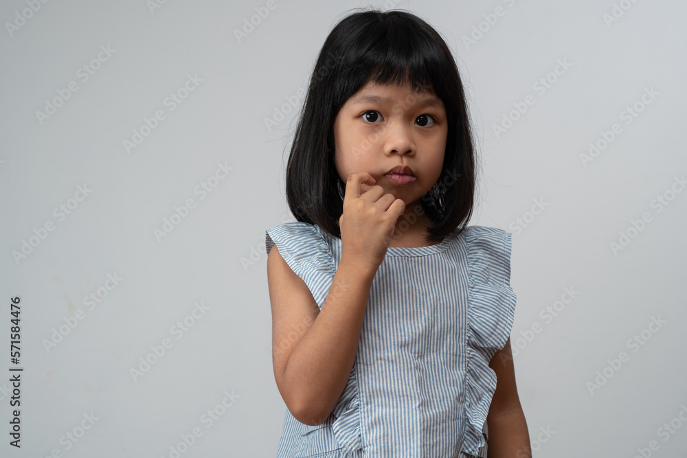 Portrait of Asian child 5 year old and to collect hair and Place her hands on her chin and make thinking pose on isolated white background, She is Happiness, radiance in youth, Education Concept Portrait of Asian child 5 year old and to collect hair and Place her hands on her chin and make thinking pose on isolated white background, She is Happiness, radiance in youth, Education Concept