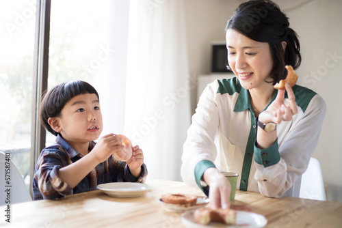 おやつのドーナツを食べる母親と男の子 photo